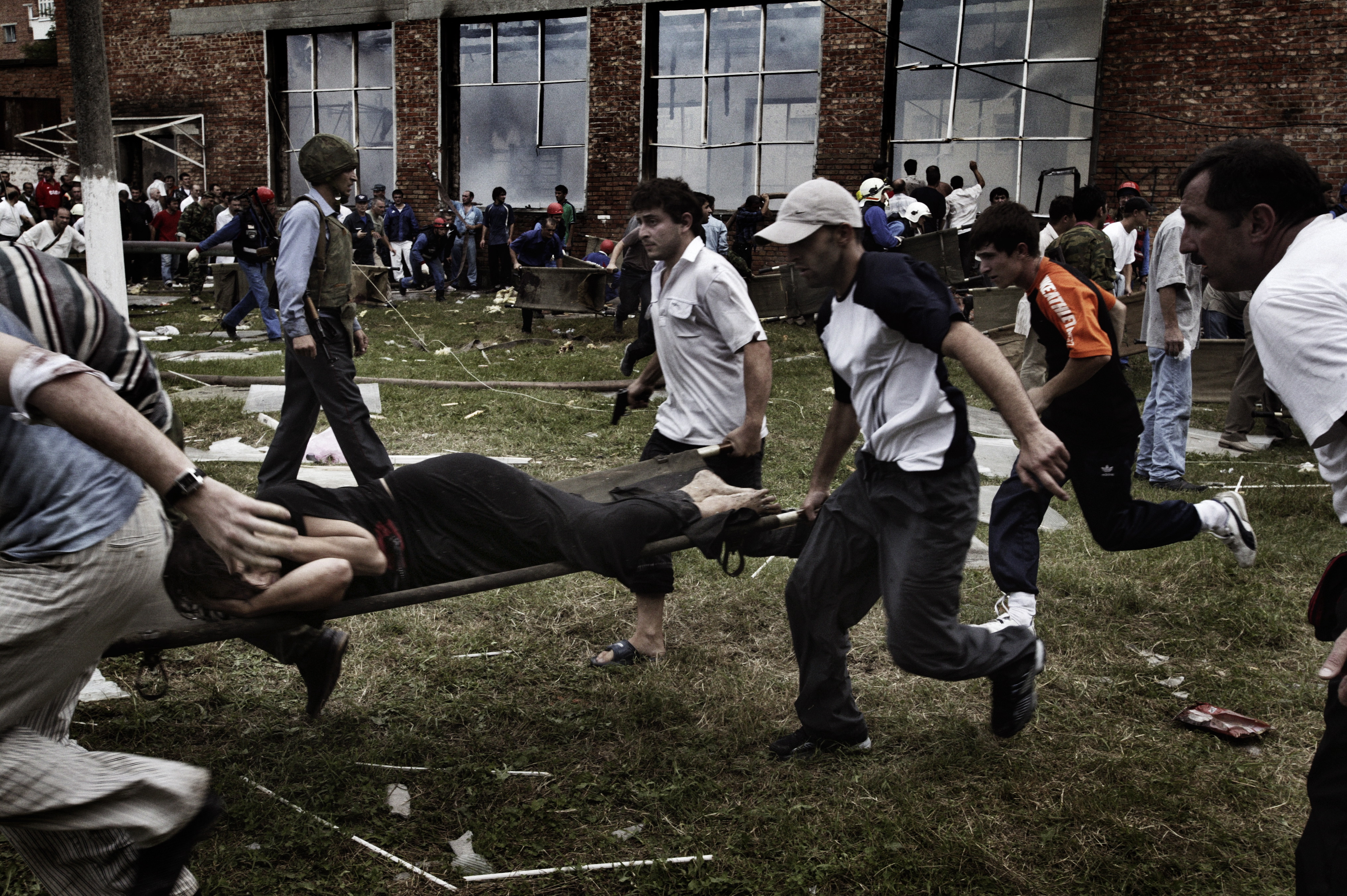 Эвакуация раненых заложников из здания школы в Беслане, 3 сентября 2004 года. Всего в ходе трагедии погибло 334 человека / Фото: Юрий Козырев, NOOR