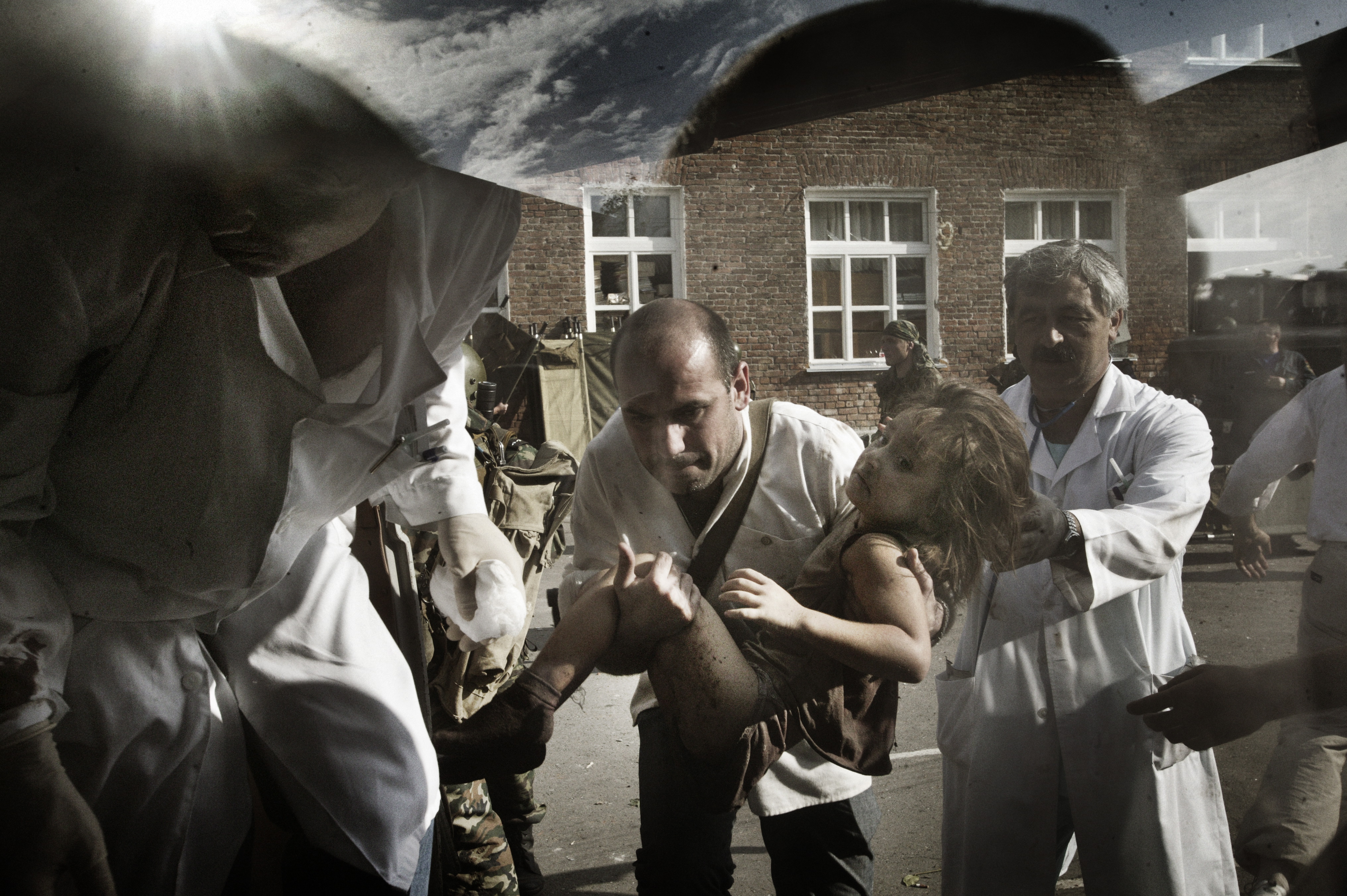 Эвакуация раненых заложников из здания школы в Беслане, 3 сентября 2004 года. Погибли 17 сотрудников школы / Фото: Юрий Козырев, NOOR