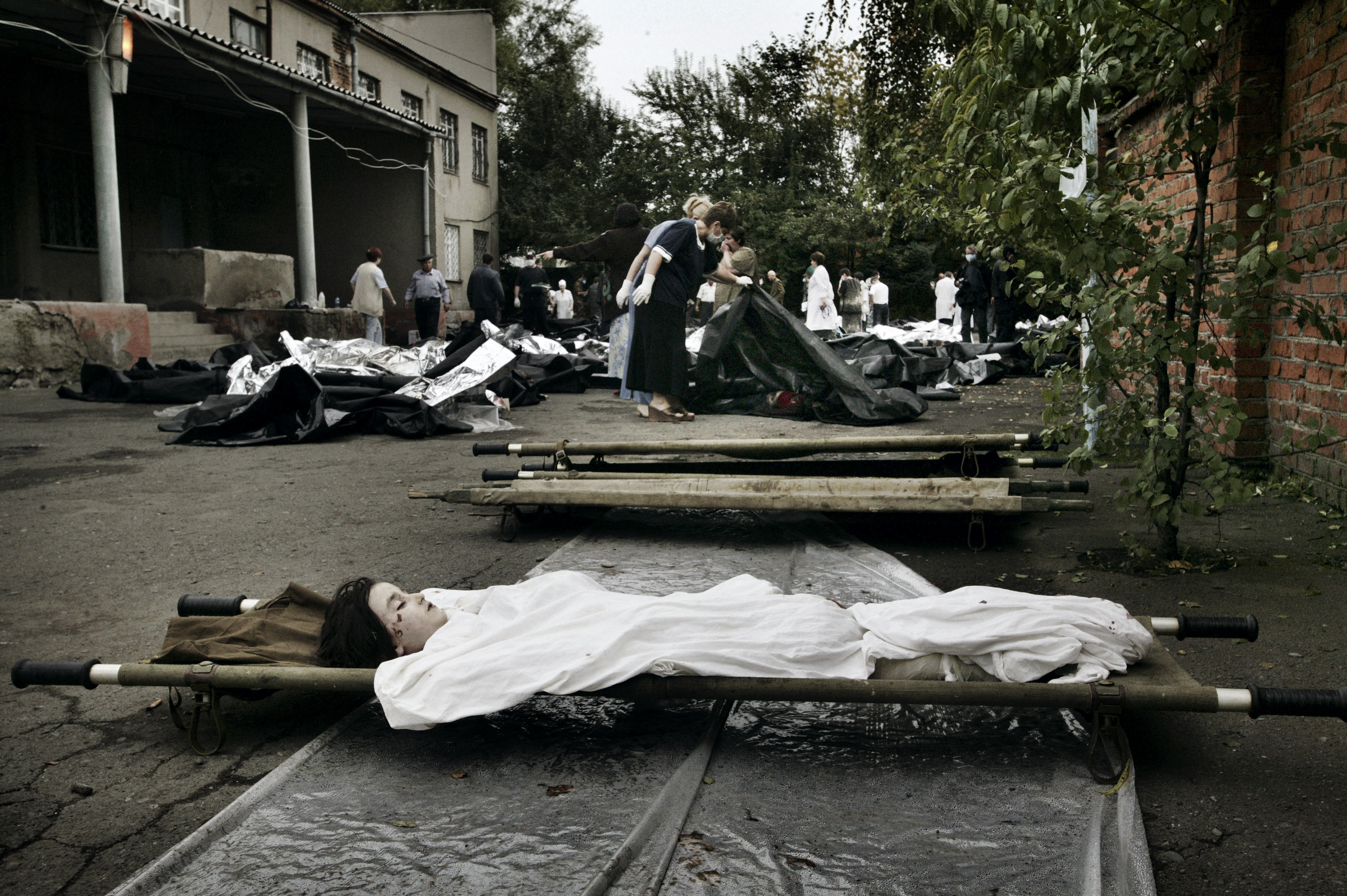 Эвакуация раненых заложников из здания школы в Беслане, 3 сентября 2004 года. Погибших детей — 186 / Фото: Юрий Козырев, NOOR